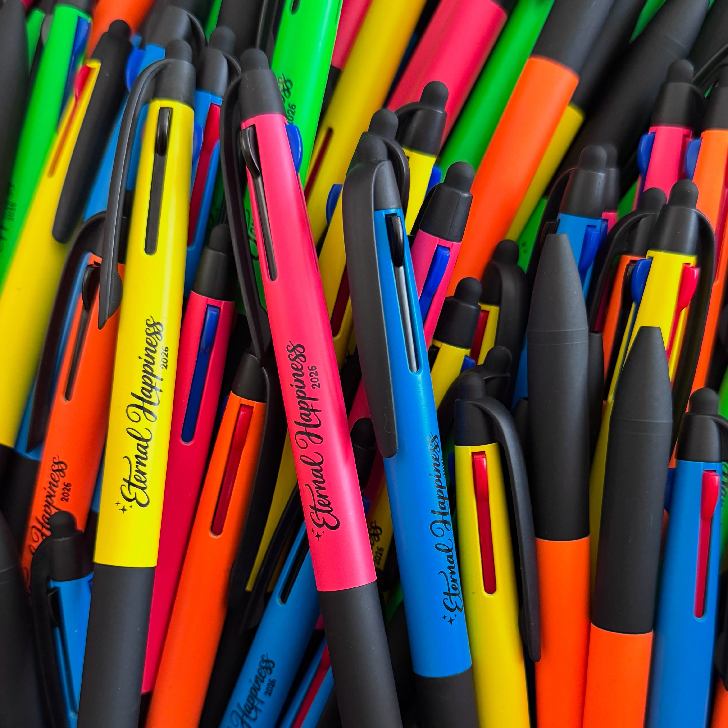 Assorted colorful pens with 'Eternal Happiness' branding.